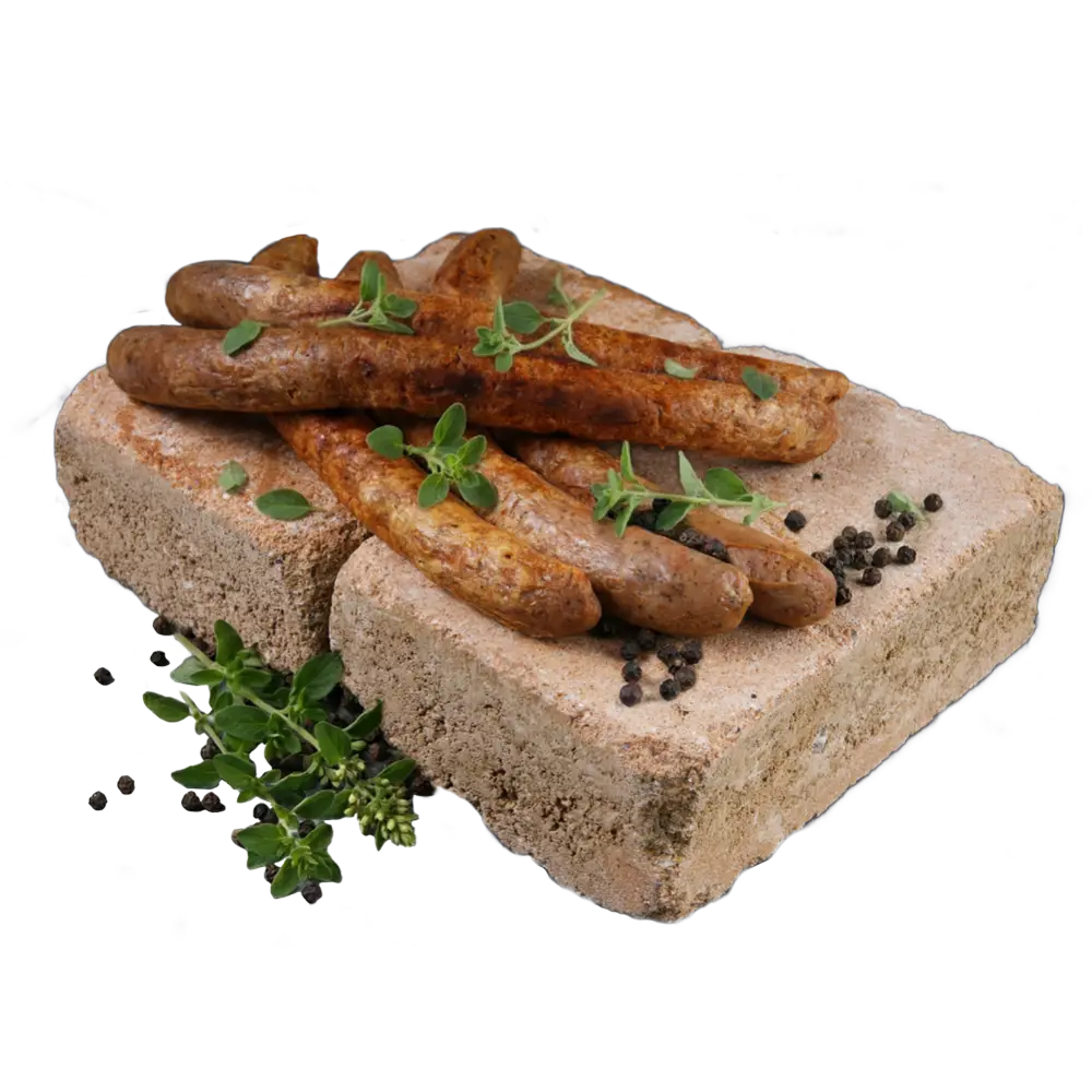 Mehrere gegrillte Bratwürste auf dekorativ arrangierten Sandsteinen, garniert mit frischen Kräutern und Pfefferkörnern