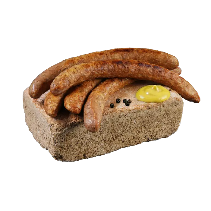Gegrillte Würste, angerichtet auf einem Sandstein mit Senfklecks und Pfefferkörnern